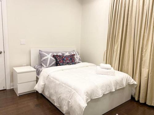a white bedroom with a white bed and a window at Dazzling Modern Home Next to Beach & Go in Pickering