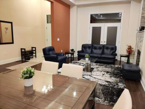 a living room with leather chairs and a table at Dazzling Modern Home Next to Beach & Go in Pickering