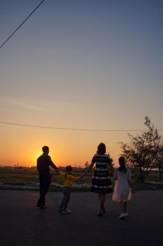 a family flying a kite with the sunset in the background at Angel Garden Villa in Hoi An