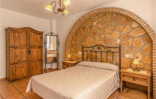 a bedroom with a bed and a stone wall at Nice Home In Mecina Bombarón With Wifi in Mecina Bombarón