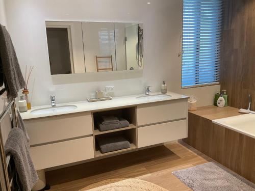 a bathroom with two sinks and a large mirror at Blue House By The Sea Adult Retreat in Kinross