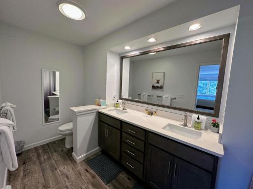 baño con lavabo y espejo grande en F7 Comfortable golf course townhouse within walking distance of Mount Washington Hotel en Carroll