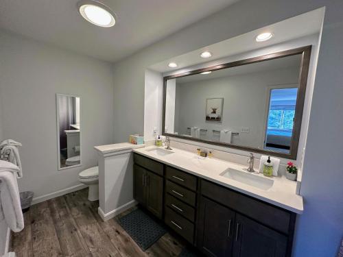 ein Badezimmer mit Waschbecken und großem Spiegel in der Unterkunft F7 Comfortable golf course townhouse within walking distance of Mount Washington Hotel in Carroll