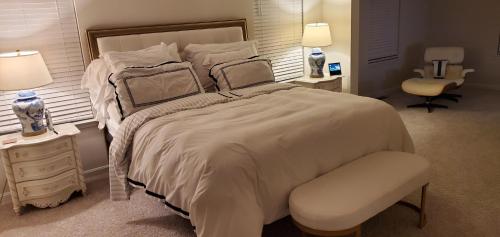 528 Carroll Walk Avenue في فريدريك: غرفة نوم بيضاء بسرير كبير وكرسي