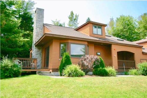 a brown house with a porch and a lawn at O8 Renovated Forest Cottage Townhome with great Mt Washington views fast wifi Walk to skiing in Carroll