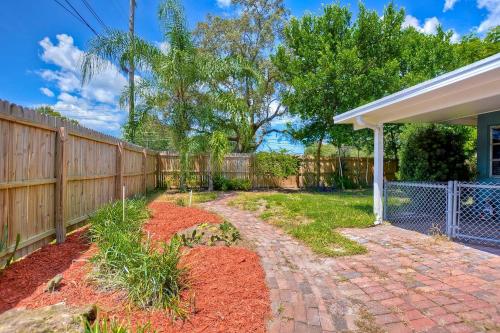 a backyard with a fence and a brick driveway at Spacious 5 bedrooms 3 bathrooms Family-Friendly Home With Heated salt Pool in Clearwater