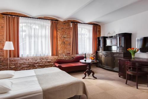 une chambre d'hôtel avec un lit et un fauteuil rouge dans l'établissement Janne Hotel, à Riga