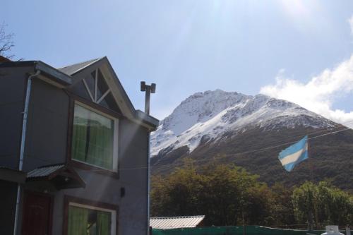 a blue flag flying in front of a mountain at Caballo de Fuego in Ushuaia