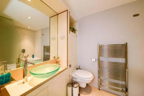 a bathroom with a sink and a toilet and a mirror at MR2 - Fantastic 1 Bed apartment Munster Village in London