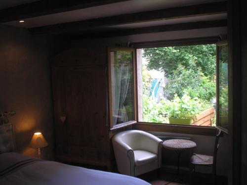 - une chambre avec une fenêtre, une chaise et un lit dans l'établissement La Maison Du Bonheur, à Aups