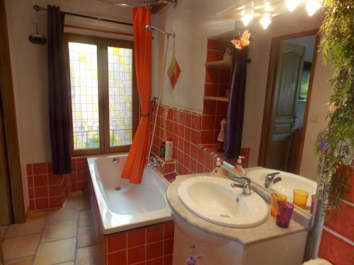 La salle de bains est pourvue d'un lavabo et d'une baignoire à côté d'un lavabo. dans l'établissement La Maison Du Bonheur, à Aups