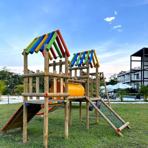 a wooden playground with a slide in a park at Hotel Capri Doradal in Doradal