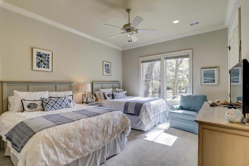 una camera con 2 letti, una TV e una sedia di Vacation Home 2 Kings 7 Queens 2 Sleeper Sofas Bikes & Beach Gear Included a Hilton Head Island