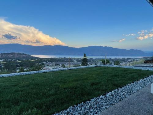 a garden with a view of the water and mountains at Shannon Heights B&B in West Kelowna