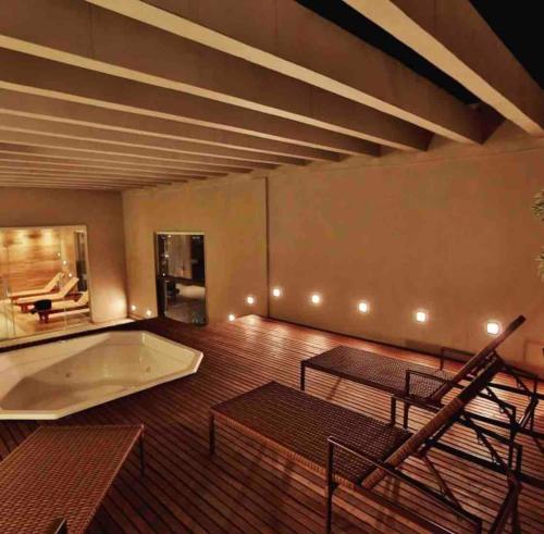 Cette chambre dispose d'une baignoire, d'une table et de chaises. dans l'établissement Quarto Executivo para Sua Estadia de Trabalho, à Campos dos Goytacazes