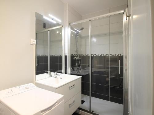 une salle de bain avec une douche, un lavabo et un miroir dans l'établissement Charmant T2 avec balcon, parking privatif, idéalement situé au Mont-Dore, proche centre et thermes - FR-1-608-244, à Le Mont-Dore