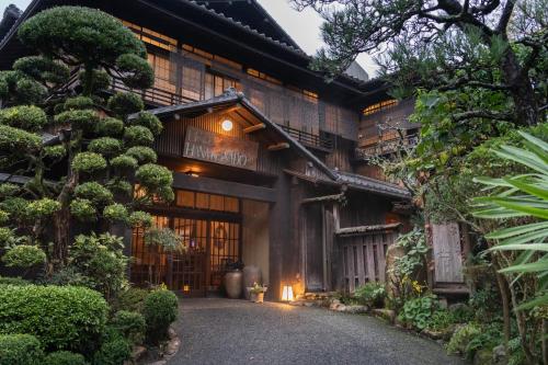 a japanese house with a pathway in front of it at Hotel Hanakoyado in Kobe