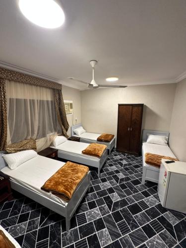 a room with three beds in a room at فندق الفخامة اوركيد 2 للغرف والشقق المفروشة in Makkah