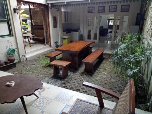a patio with wooden benches and a table at Omah Ndanu Homestay in Yogyakarta