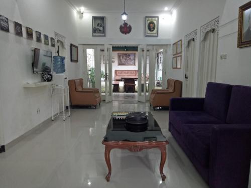 a living room with a purple couch and a table at Omah Ndanu Homestay in Yogyakarta