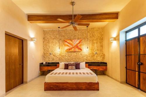 a bedroom with a bed and a ceiling fan at CASA YAXCHE luxury house in downtown Mérida in Mérida