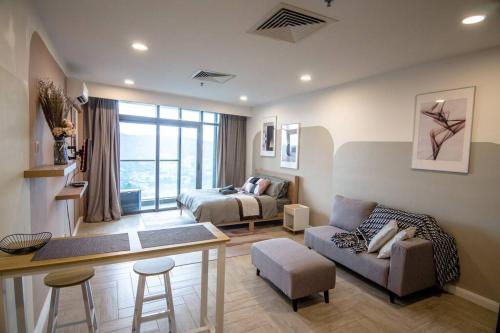 ein Wohnzimmer mit einem Bett und einem Schreibtisch in einem Zimmer in der Unterkunft KL Exquisite Minimalist Balcony Suite Empire City Marriot in Petaling Jaya