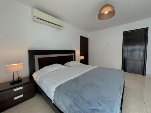 a bedroom with a large bed with a blue blanket at Apartamento Boutique en Avenida Balboa in Panama City