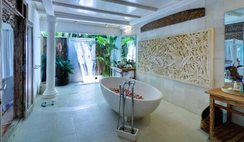 ein Bad mit einer großen Badewanne in einem Zimmer in der Unterkunft Villa Sipo in Seminyak