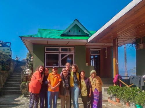 a group of people standing in front of a house at 3 Sisters' Homestay in Ravangla