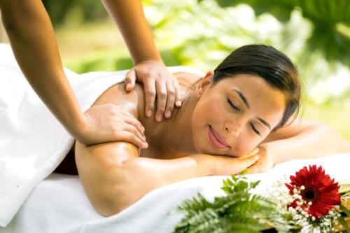a woman getting a massage from a therapist at Furaveri Maldives in Raa Atoll