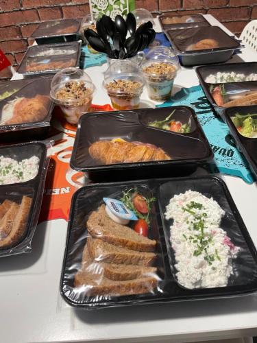 a table topped with trays of different types of food at Pokoje Gościnne FRESCO in Łódź