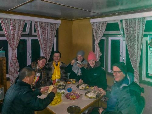 a group of people sitting around a table eating at 3 Sisters' Homestay in Ravangla