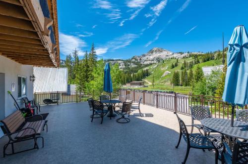 a patio with tables and chairs and a view of a mountain at Majestic Suite 5 Bedroom Brighton Chalet in Brighton