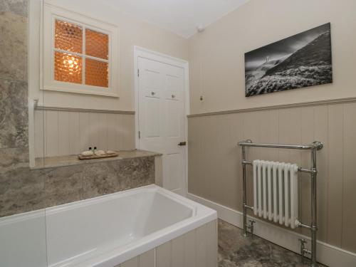een badkamer met een bad en een raam bij Kylemore in Glastonbury