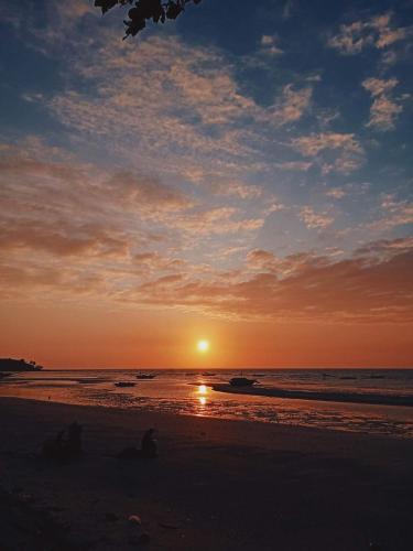 a sunset on a beach with the sun setting at Treasure Beach Resort in Carles