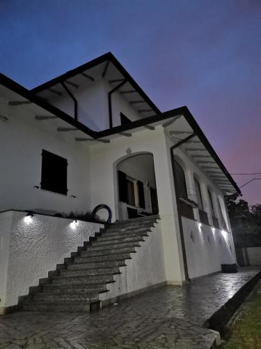 a white building with stairs in the night at Villa Flora Affittacamere in Luni
