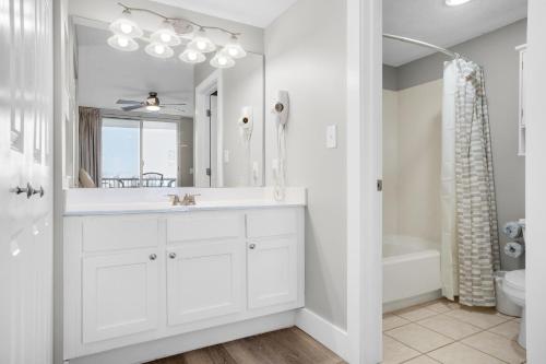 uma casa de banho branca com um lavatório e um espelho em Pelican Beach Terrace 805 em Destin