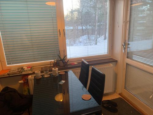 a dining room with a table and two windows at Very Nice Apartment 15 minutes from Stockholm in Trångsund