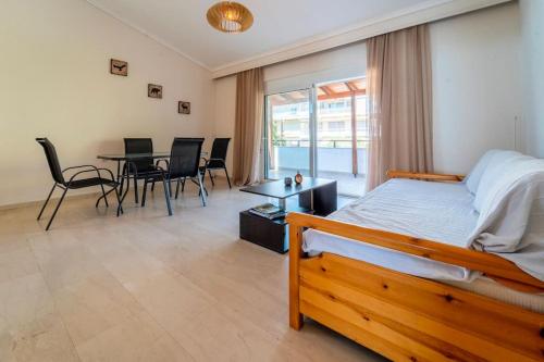 um quarto com uma cama, uma mesa e cadeiras em Veta Apartment - Seaview em PalaiónTsiflíkion