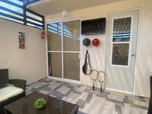 a living room with two tennis rackets on the wall at CASABONITA II, pie alberca, AirAc in Xochitepec