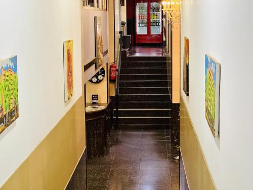 a long hallway with stairs and a red door at Yaahot in Yaoundé