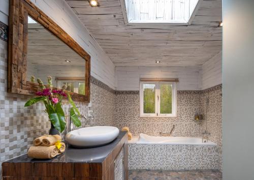 y baño con bañera y lavamanos. en The Gardener's Cottage, en Ubud