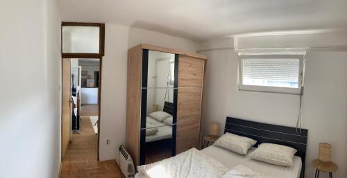 une chambre avec un lit et un grand miroir dans l'établissement Penthouse stan 80m2, terasa 36m2, garaža... centar Banja Luke - gradski park, à Banja Luka