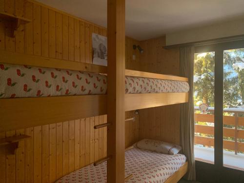 een slaapkamer met 2 stapelbedden en een raam bij Peak-view Crans-Montana in Crans-Montana