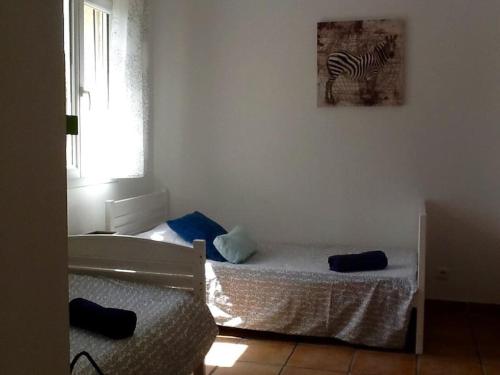 1 dormitorio con 1 cama y una foto de cebra en la pared en LE PALADIN Porto Pollo Villa privée avec piscine chauffée en Serra-di-Ferro