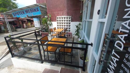 MALAKUI Bed&Coffee في Enrekang: مجموعة من الكراسي والطاولات على الشرفة