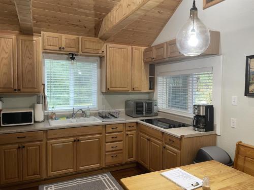 a kitchen with wooden cabinets and a sink and a table at Our Cozy Getaway in Ocean Park