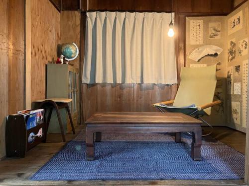 a room with a bench and a chair and a window at 桜山ノウチ in Zushi