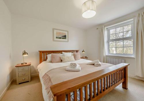 a bedroom with a large bed with two towels on it at Netherend in Oxwich
