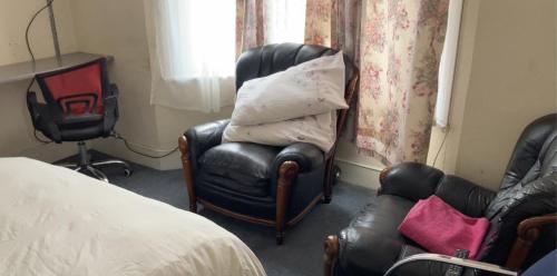 1 dormitorio con silla y silla en Rooms To Let In London en Londres